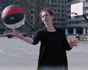 Laura spinning a basketball on her finger.