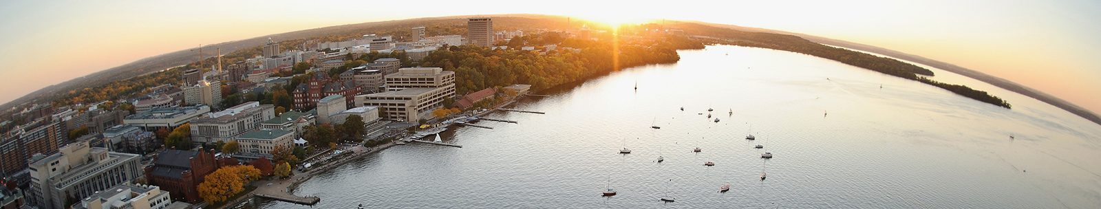 Boats dot Lake Mendota in a fisheye-lens aerial view of the University of Wisconsin-Madison campus during an autumn sunset on Oct. 5, 2011. Major campus facilities pictured along the shoreline, from left to right, include the Pyle Center, Below Alumni Center, Armory and Gymnasium (Red Gym), the Memorial Union Terrace, Helen C. White Hall and Picnic Point. The photograph was made from a helicopter looking southwest. (Photo by Jeff Miller/UW-Madison)