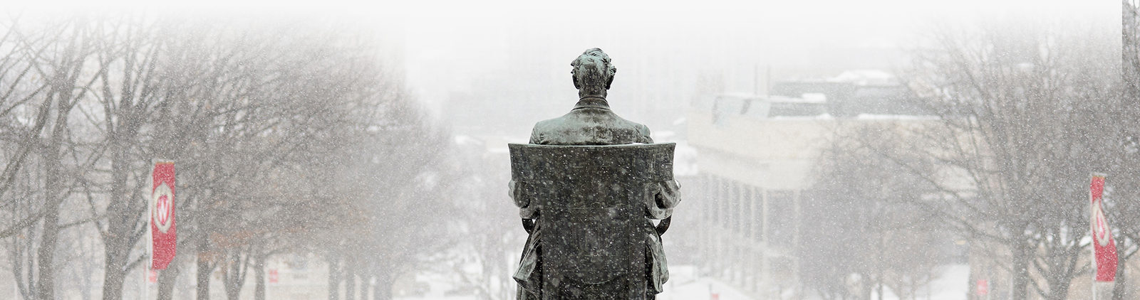 snow falling on a closeup of Abe at bascom hill.
