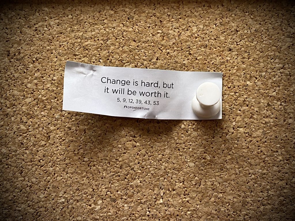 A fortune cookie script posted on a bulletin board reading “Change is hard, but it will be worth it.”
