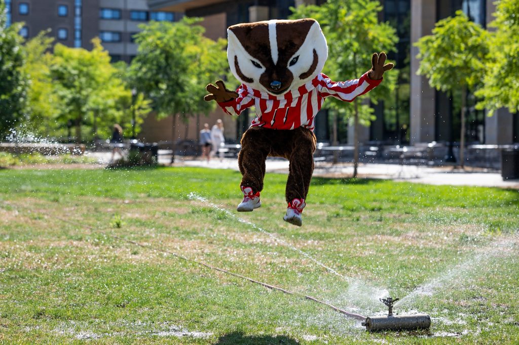 Bucky takes a break from move-in to jump over a water sprinkler.  Photo by Jeff Miller | University Communications